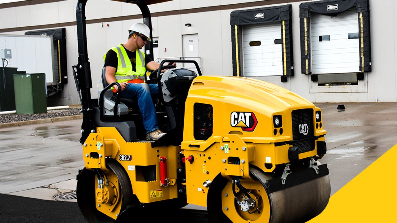 construction professional operating a CB2.7 Cat paving machine