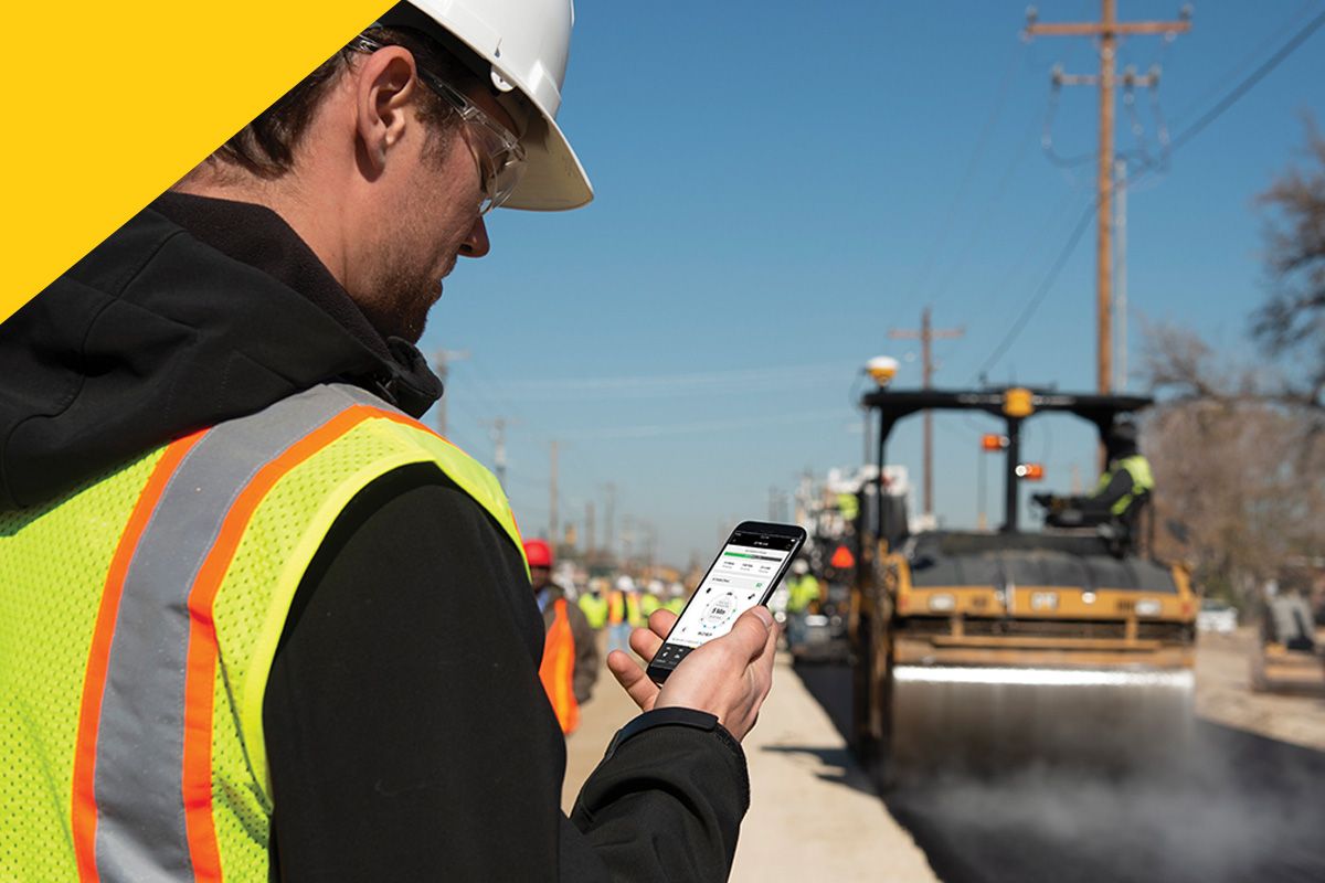 construction professional looking at phone on jobsite