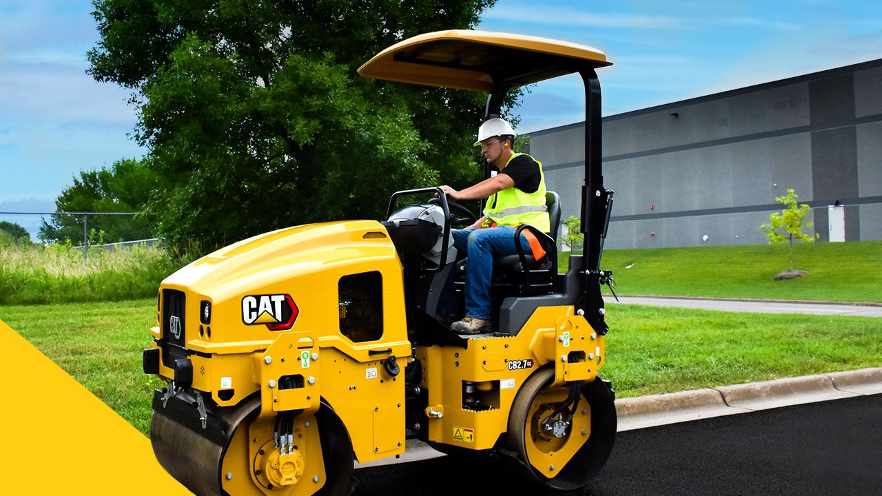 construction professional operating a CB2.7 GC Cat paving machine