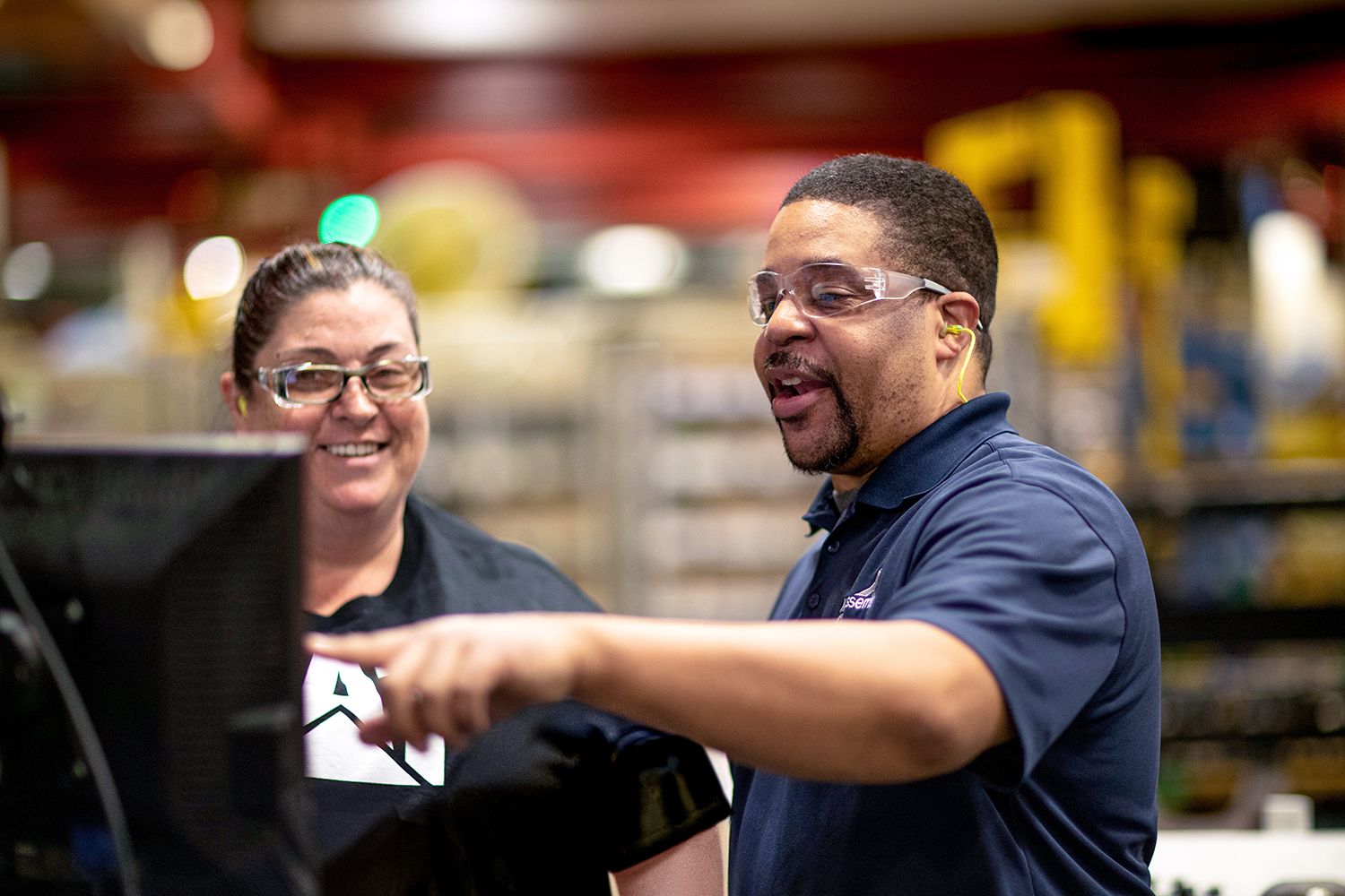 Two employees looking at a computer together.