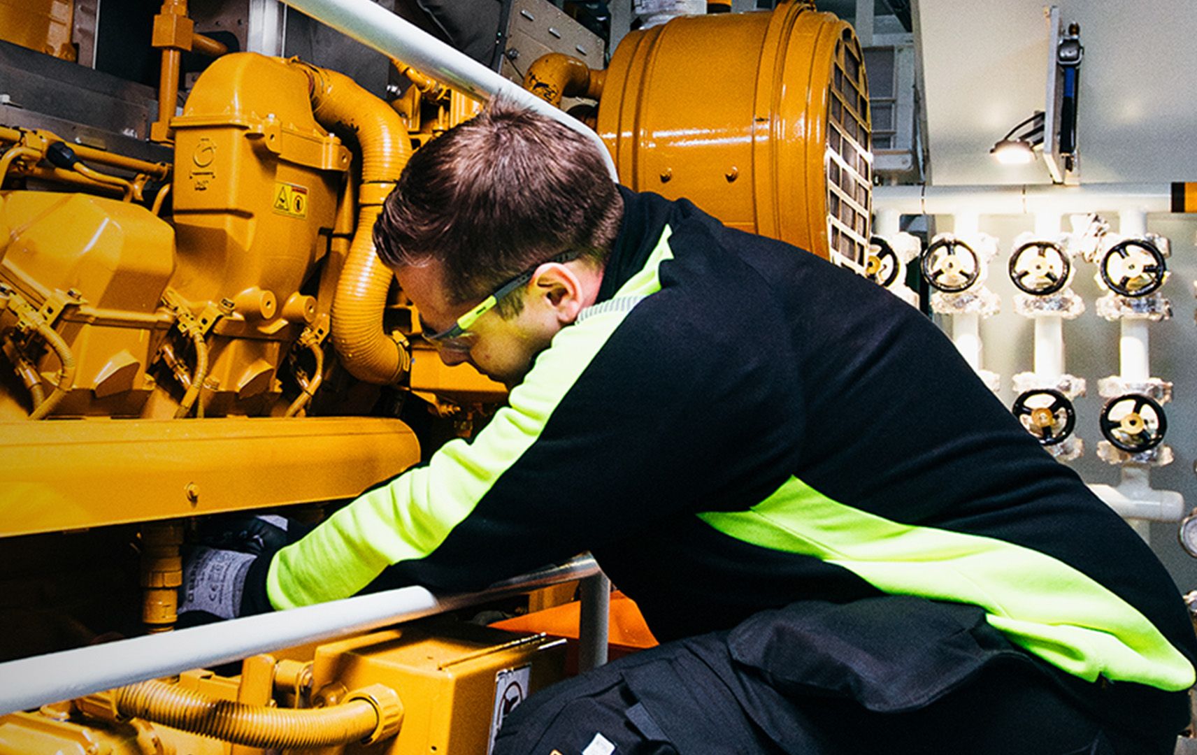 man working in the engine of a boat 