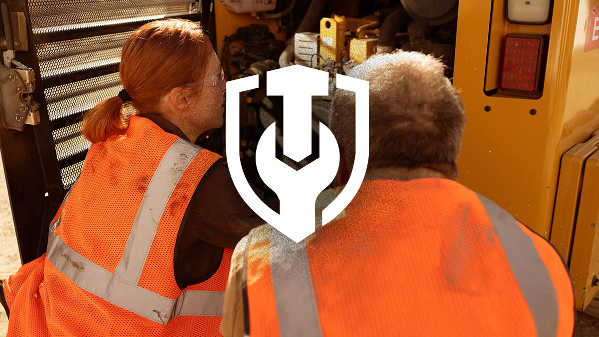 Two technicians inspect a Caterpillar generator requiring some maintenance.