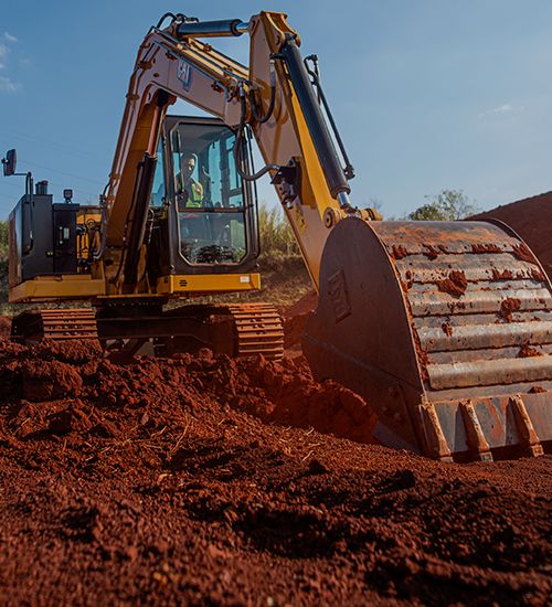 Miniexcavadora descargando tierra de la cuchara
