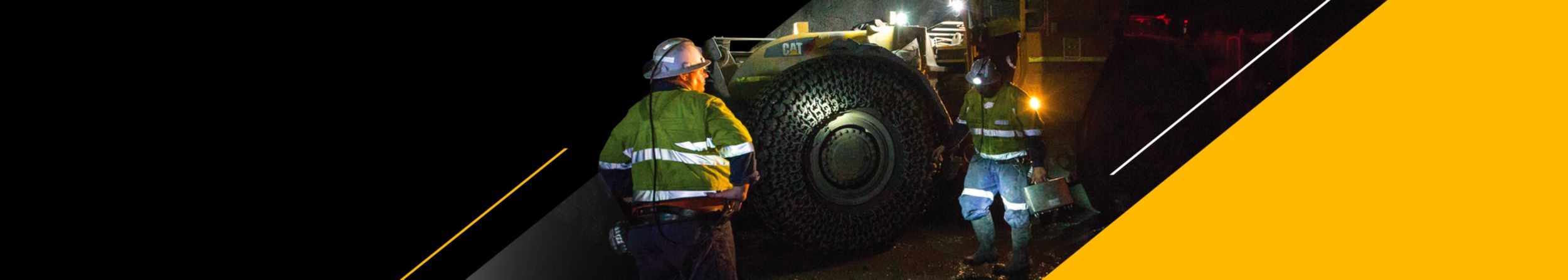 Two men near machinery in an underground mine