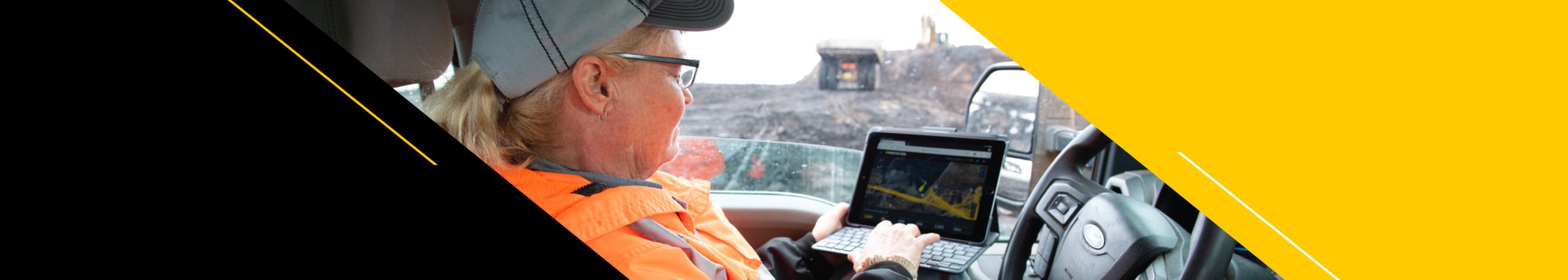 Woman viewing equipment data on portable screen in light vehicle