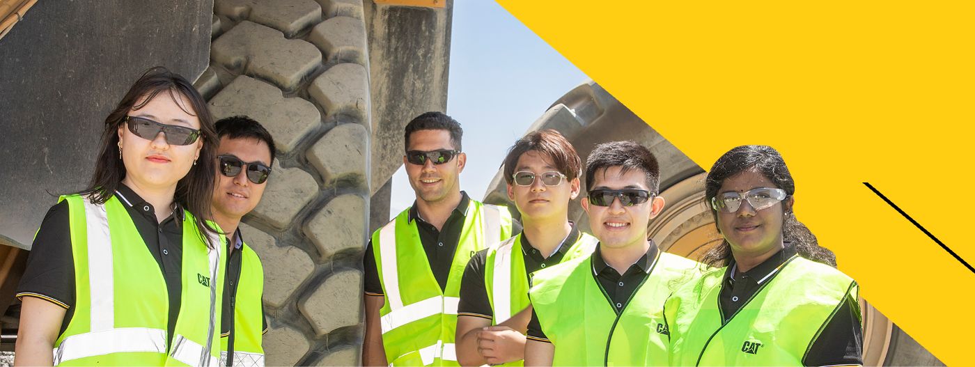 group of employees in front of a mining truck