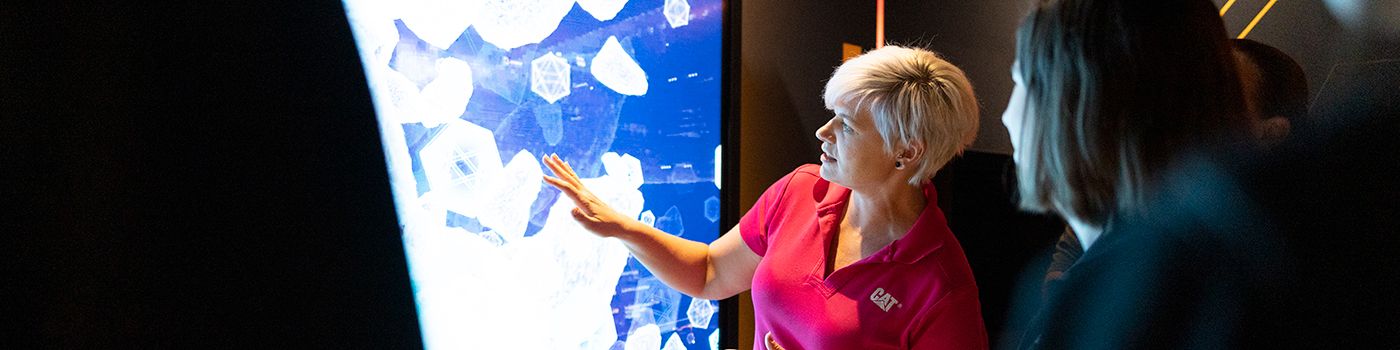 employee pointing at a presentation on a large screen