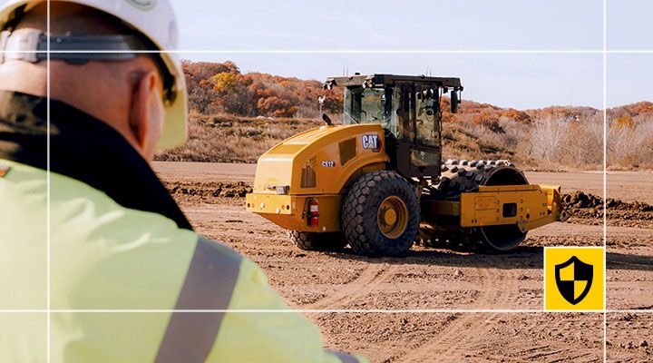 A Cat compactor operating on construction jobsite.