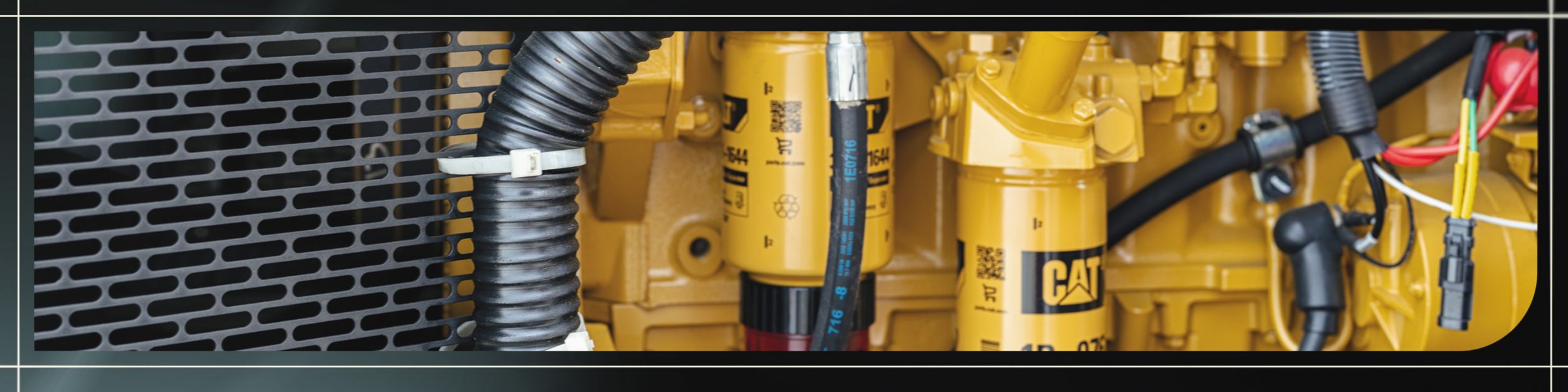 Close-up of yellow Cat industrial generator equipment with visible engine components and wiring.
