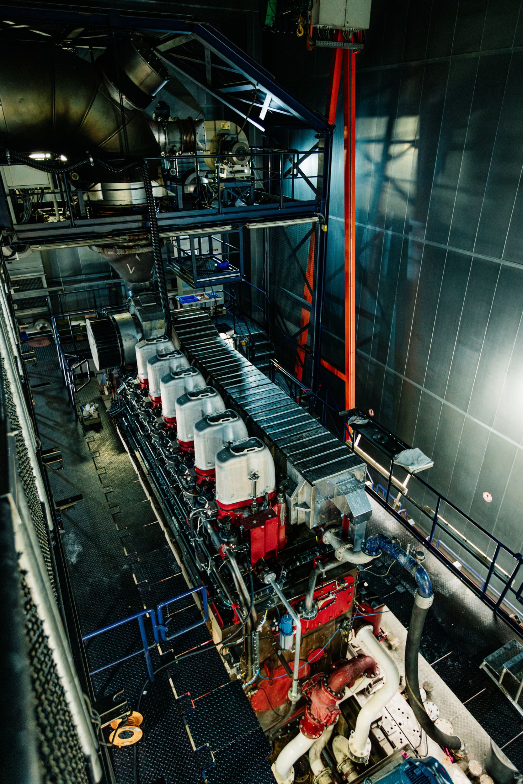 MaK engine undergoing testing in a controlled engine test facility with monitoring and support equipment.