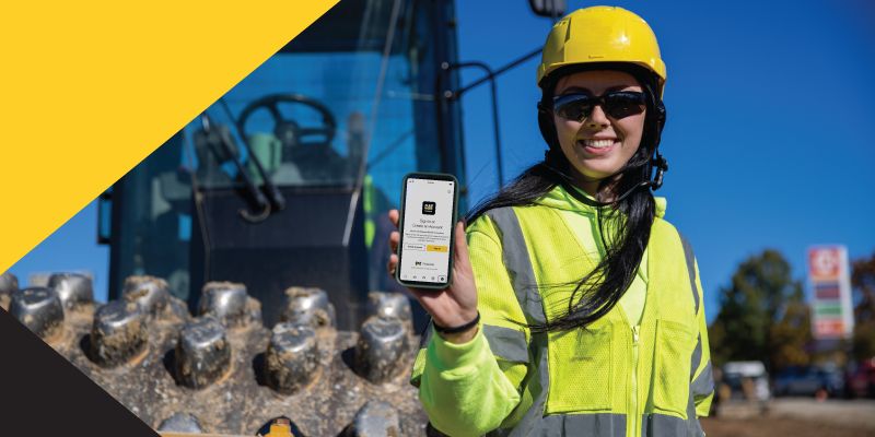 Cat employee holding cellphone displaying Cat Central