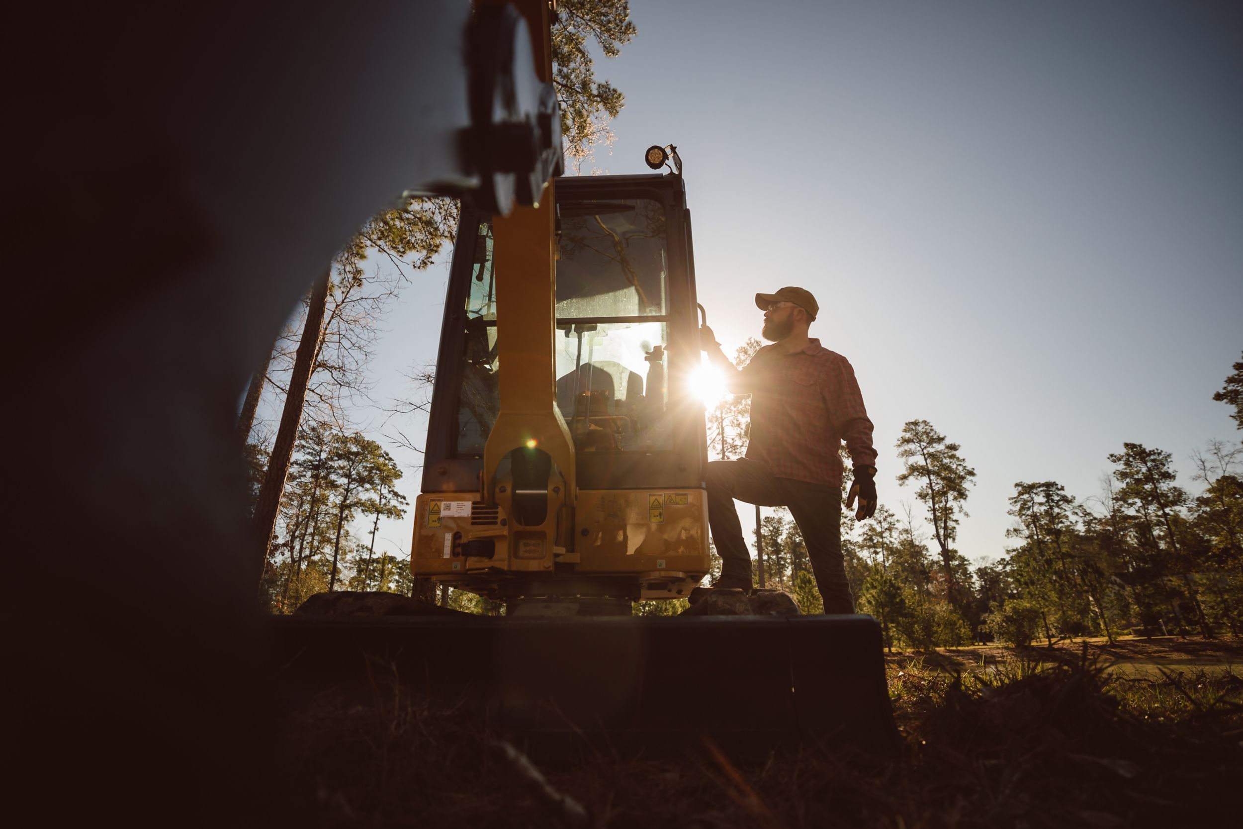 Man operating cat crane on a road site