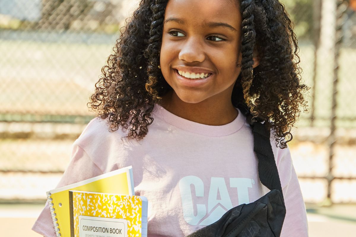 Little girl in pink t-shirt w/ fanny pack + yellow notebook