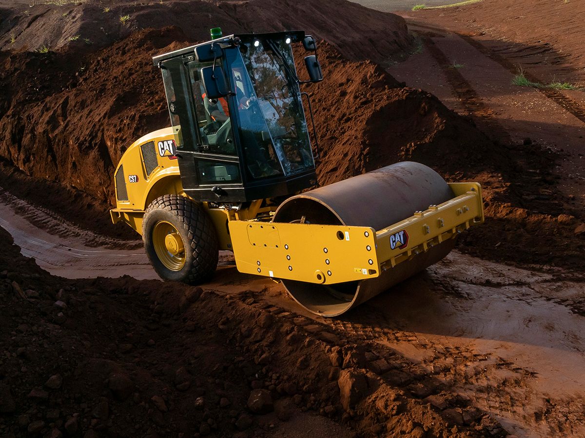 The Cat CS7 smooth drum roller climbing out of a trench.