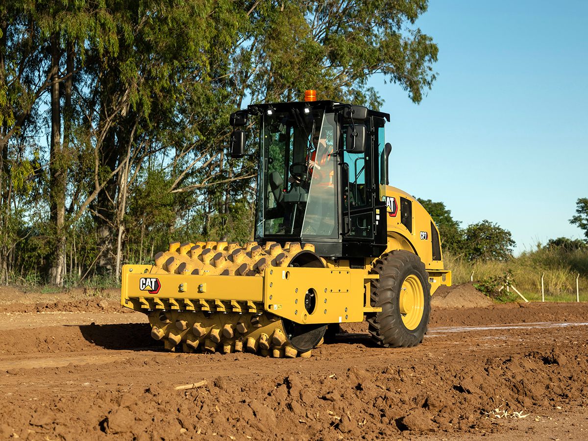The Cat CP7 sheepsfoot vibratory soil compactor working in a trench.