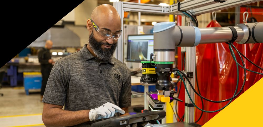 Employee wearing PPE working on tablet in manufacturing facility