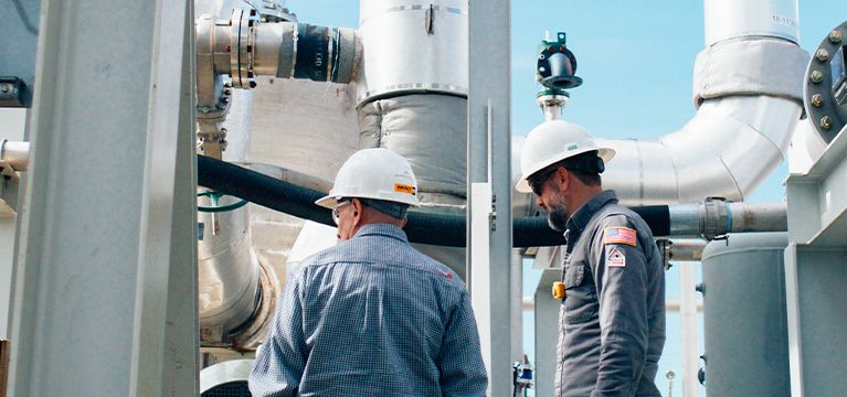 two workers looking at cat equipment