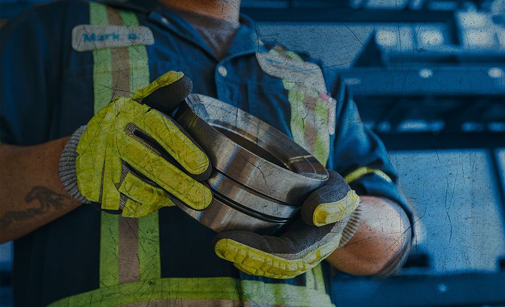 Close up of a worker's gloved hand holding a part