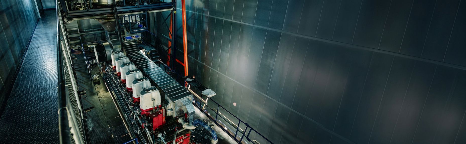 MaK engine undergoing testing in a controlled engine test facility with monitoring and support equipment.