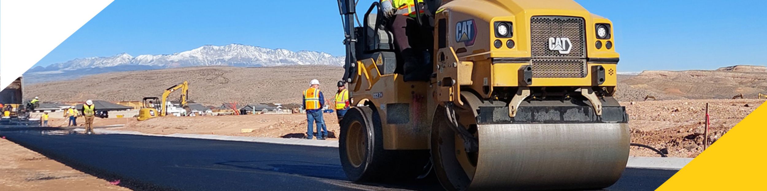 Operator using an asphalt roller on newly paved road