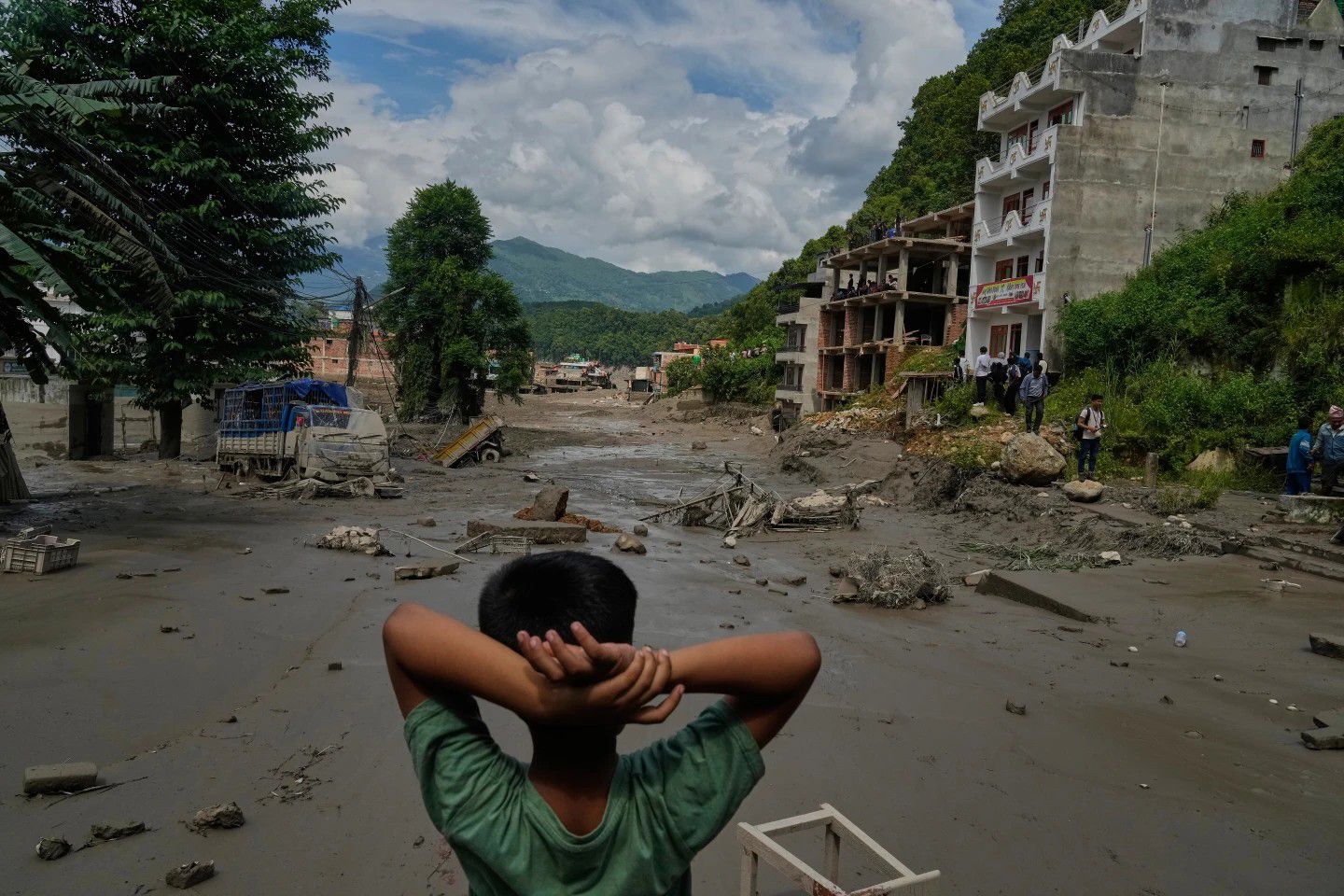 A boy looks at the devastation caused by flash flooding along the Trishuli River in Nepal's Nuwakot district, Wednesday, Aug. 26, 2026. 