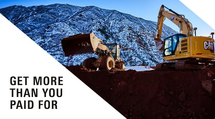 A Cat excavator and wheel loader operate at a mountainous construction site.