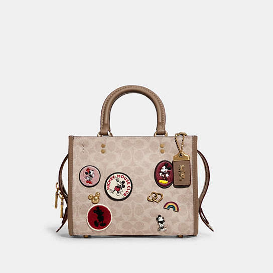 C6105 - Disney X Coach Rogue 25 In Signature Canvas With Patches Brass/Sand Taupe