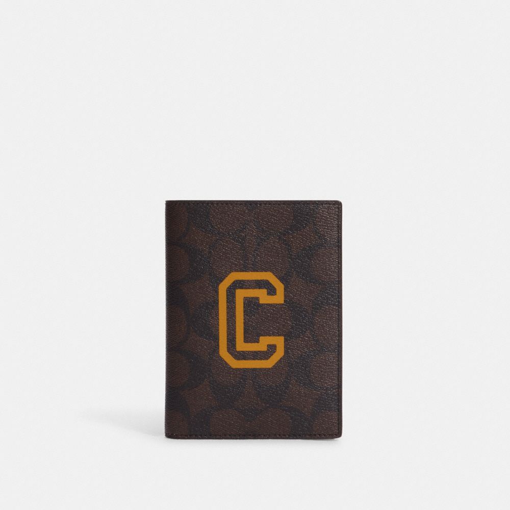 COACH CB919 Passport Case In Signature Canvas With Varsity Motif QB/Mahogany/Buttercup