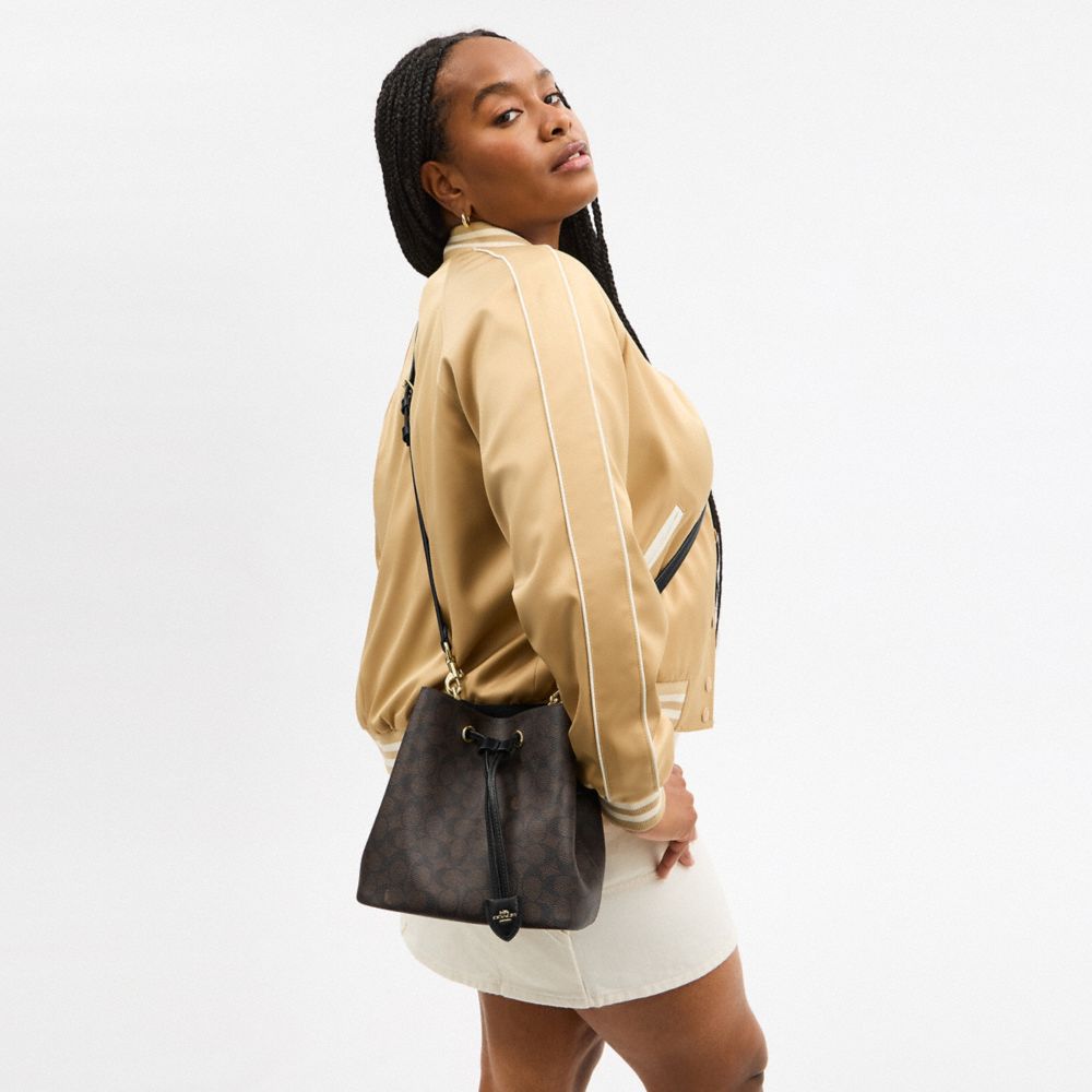 ROWAN BUCKET BAG IN SIGNATURE CANVAS