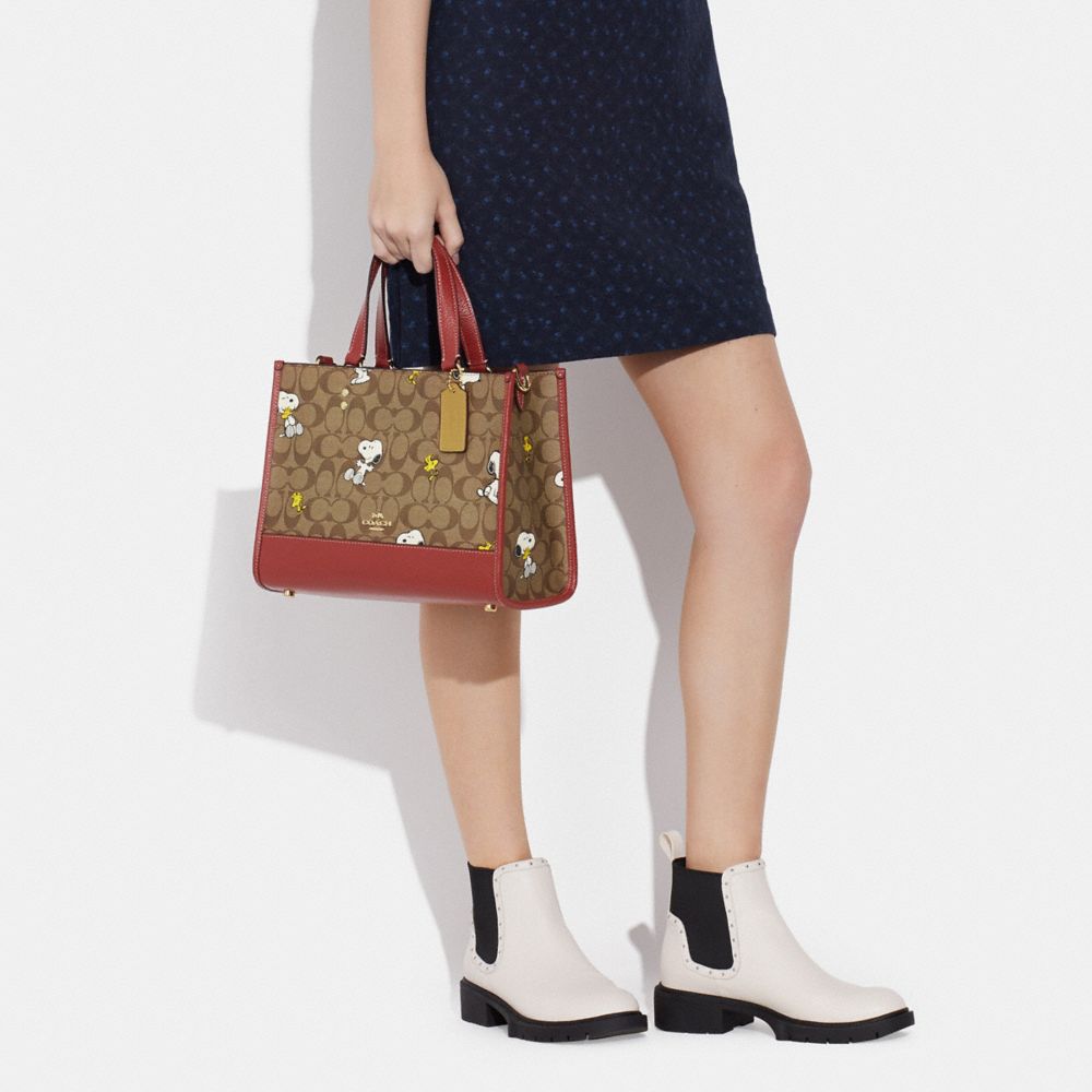 COACH X PEANUTS DEMPSEY CARRYALL IN SIGNATURE CANVAS WITH SNOOPY WOODSTOCK PRINT