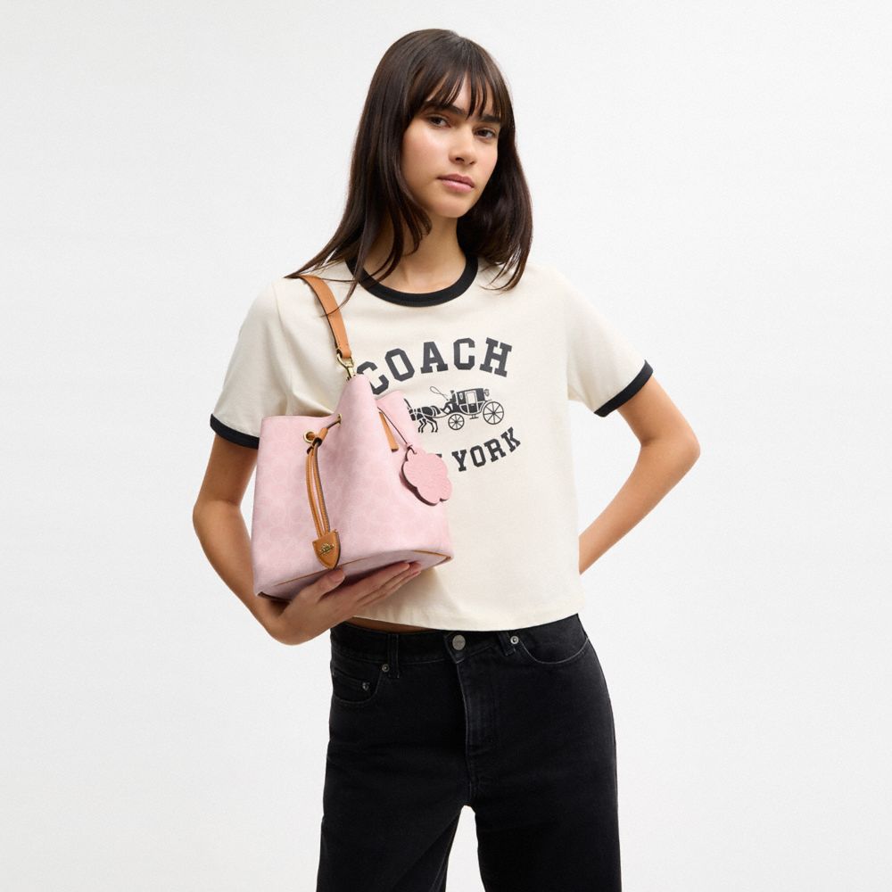 ROWAN BUCKET BAG IN SIGNATURE CANVAS WITH CHARMS