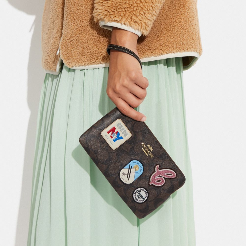 LARGE CORNER ZIP WRISTLET IN SIGNATURE CANVAS WITH SKI PATCHES