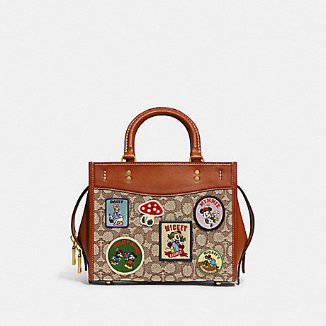 COACH CH416 Disney X Coach Rogue 25 In Signature Textile Jacquard With Patches Brass/Cocoa-Burnished-Amber-Multi