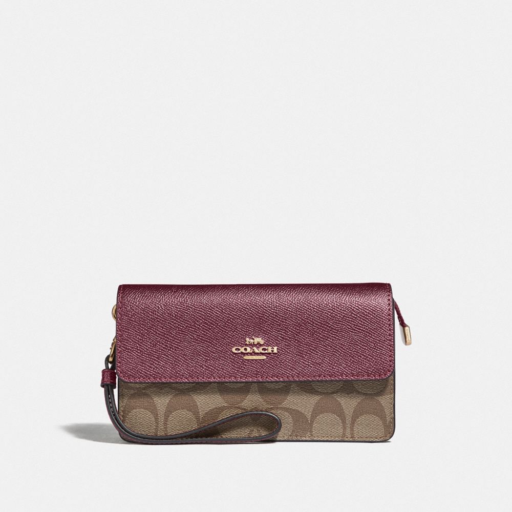 COACH FOLDOVER WRISTLET IN SIGNATURE CANVAS - IM/KHAKI METALLIC WINE - F78229