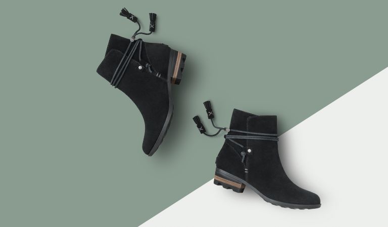 Two black booties on green and white background.