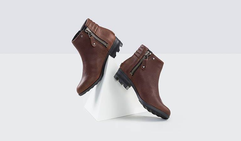 Two brown booties on white background.