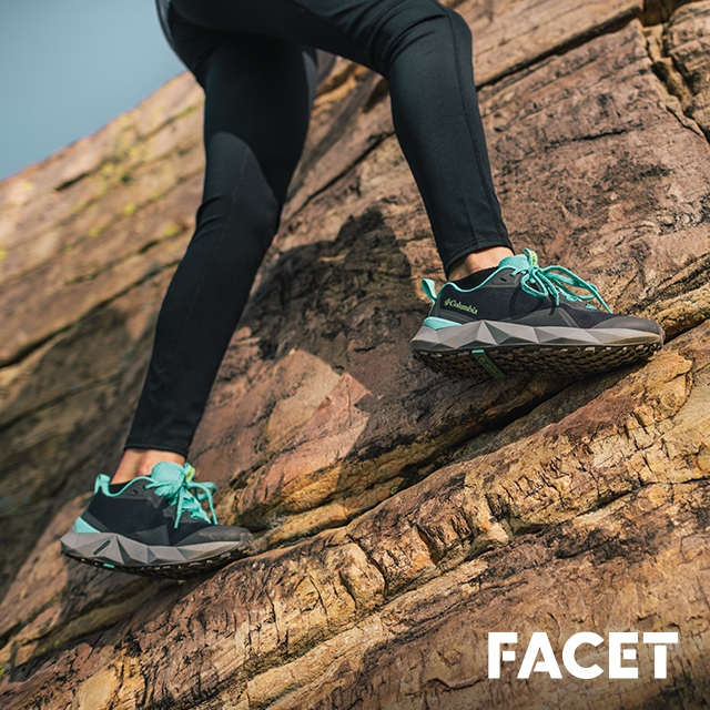 A person wearing Facet shoes hiking on rocks