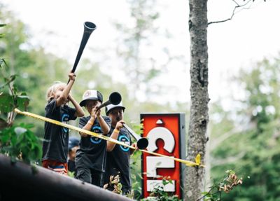 Three kids cheering on the sidelines of a Fox US Open of Mountain Bike event