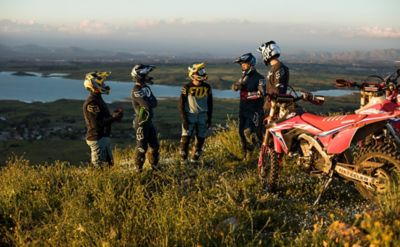 Group of ride bike riders standing and talking with a rolling hills in the distants
