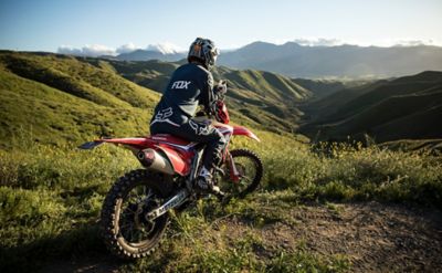 Solo dirt bike riding sitting on his bike and taking in the view