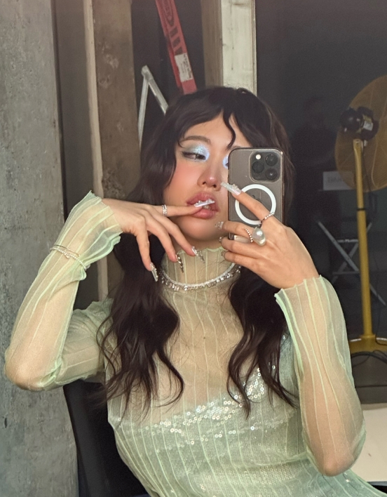 Jessica taking a selfie, striking a pose with one of her fingers on her lips.