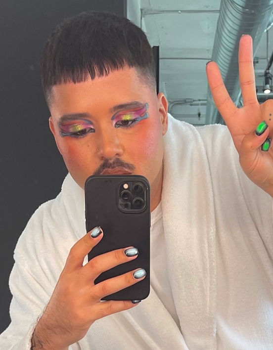 Michael taking a selfie while wearing a white robe and flashing a peace sign.