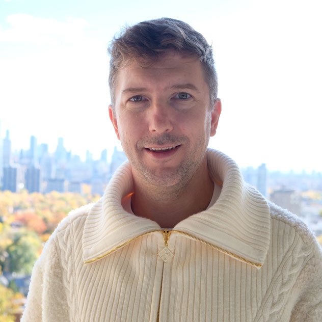 Arif sitting in the stands at a football stadium in Europe.