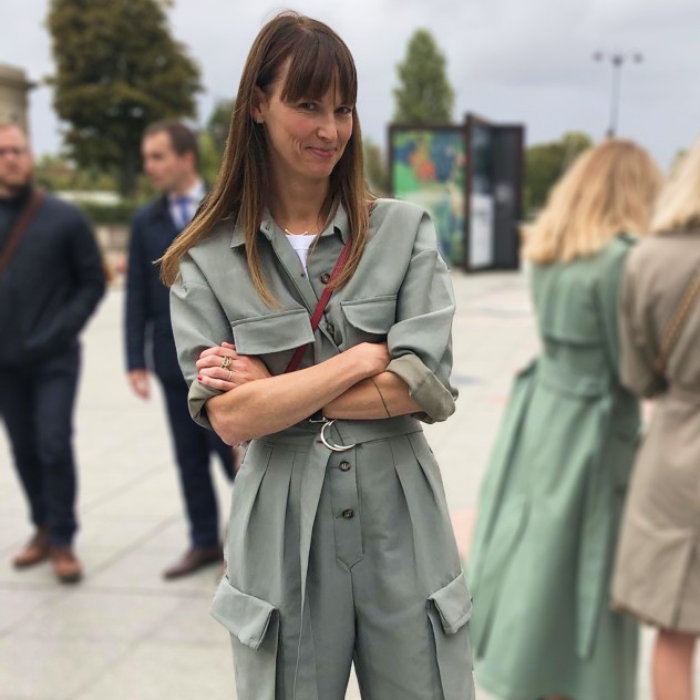 Carolyn wearing a boiler suit, posing outside of a show during fashion week.