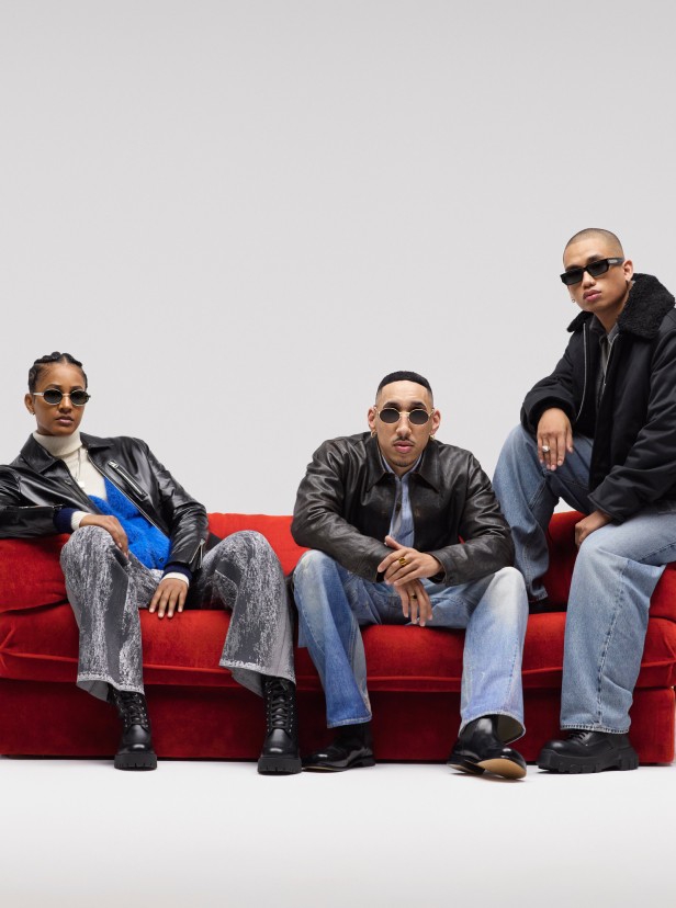The team behind BULLY Magazine posing on a red couch while wearing the latest Fall fashions.