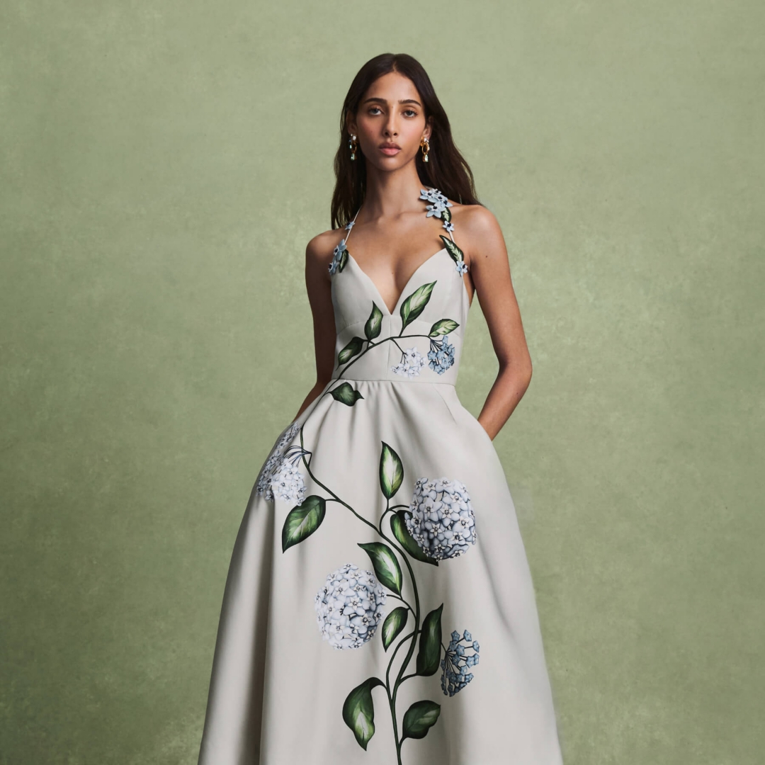 A model wearing a long dress with ivy and floral print