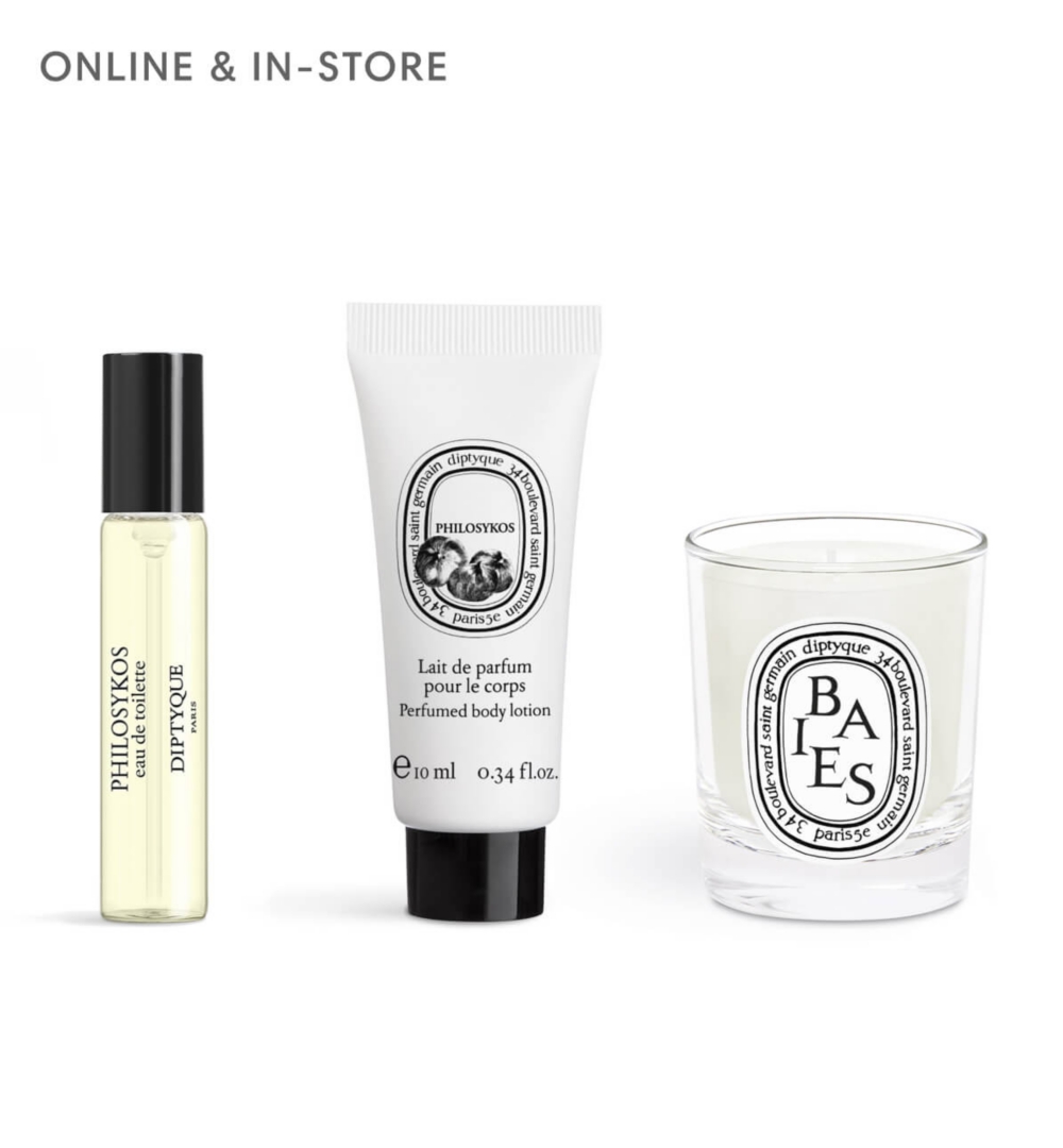 A tall clear perfume bottle with a gold