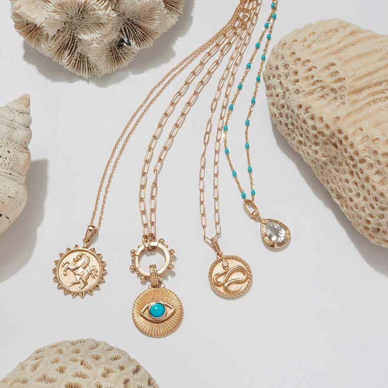 Four pendant necklaces styled side-by-side.