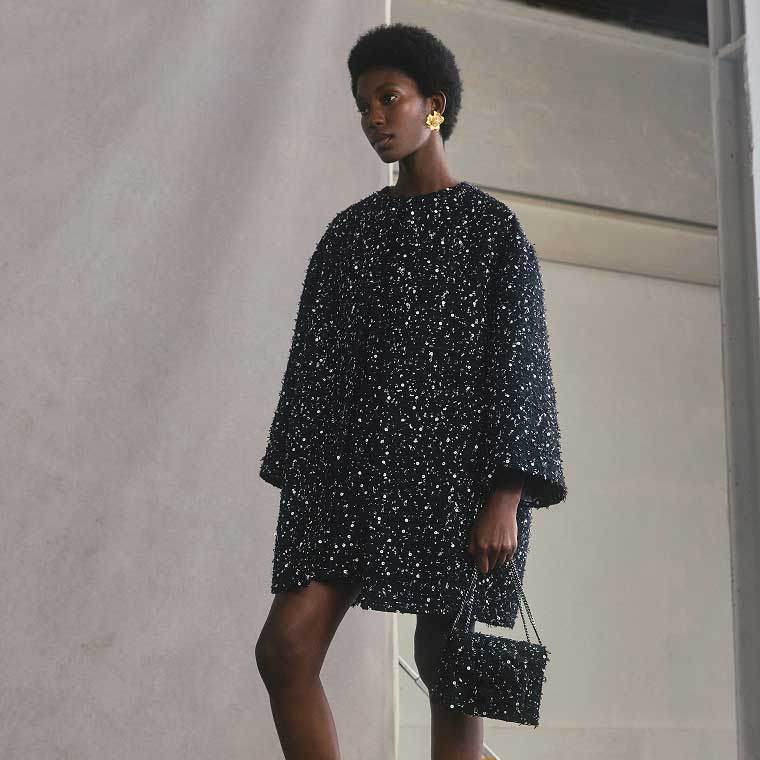 A model wearing an embroidered coat with bracelet sleeves.