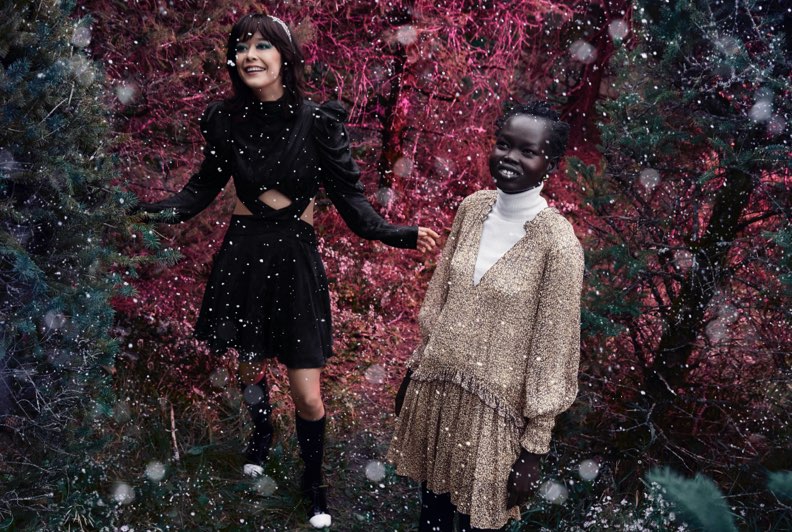 Two models wearing festive dresses exploring a hedge maze together